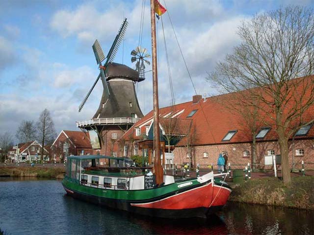 Kanalboot und Windmühle in Ostfriesland